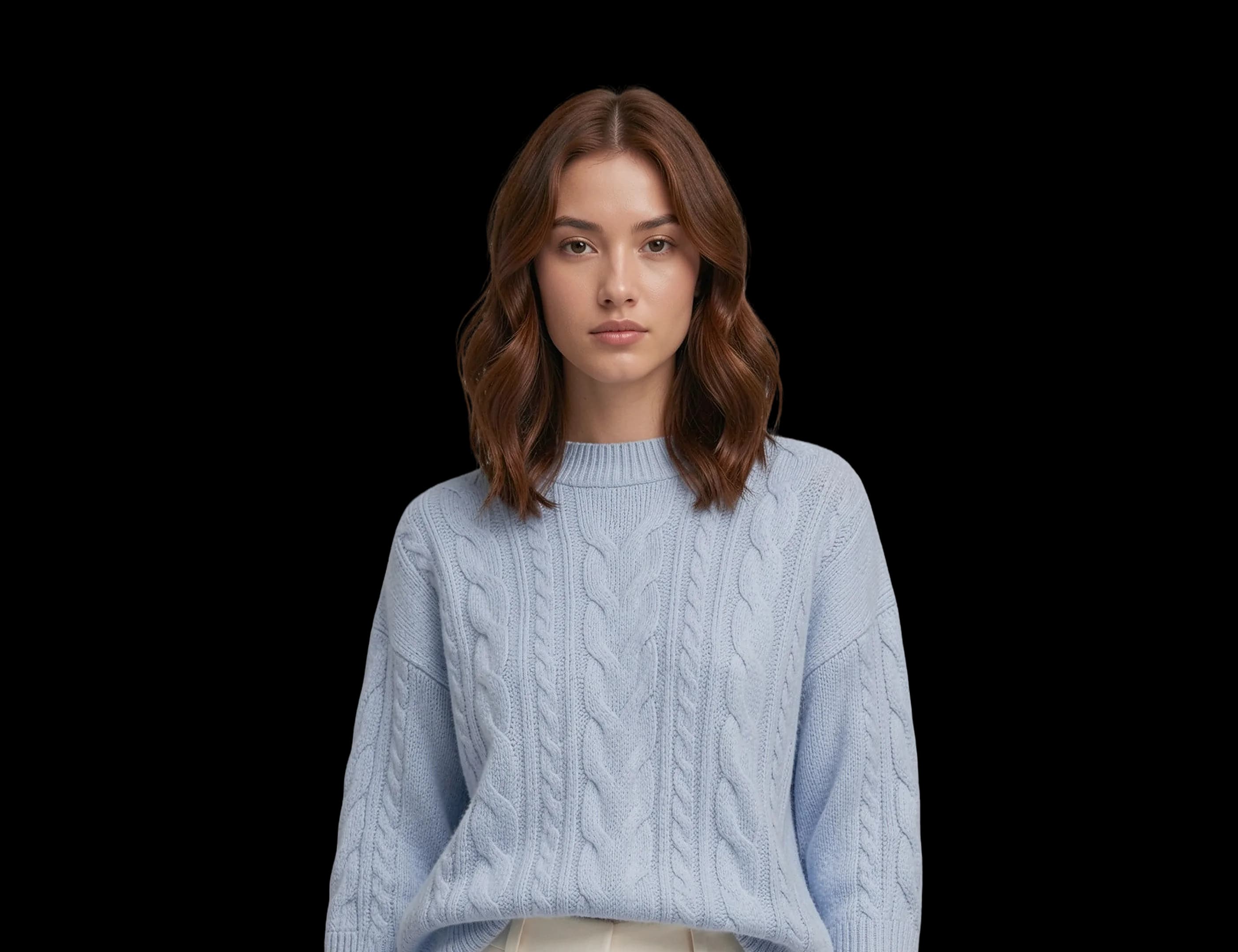 A woman in a powder-blue cable-knit sweater and cream wide trousers