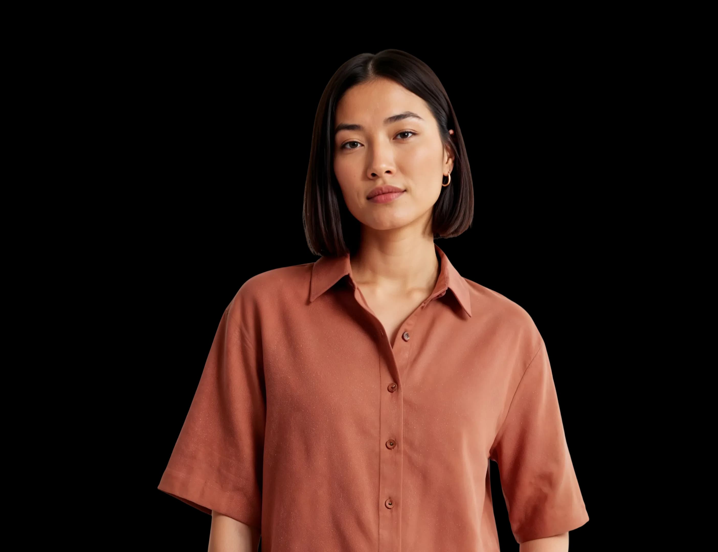 A woman in a terracotta linen shirt and matching shorts